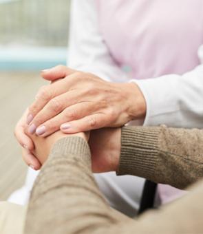 caregiver supporting patient holding hands